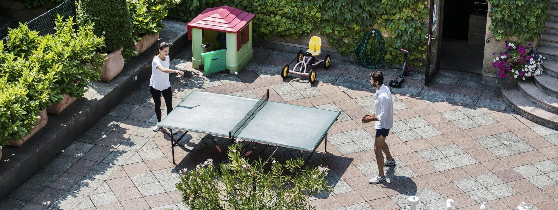 A couple is playing ping pong in the hotels garden