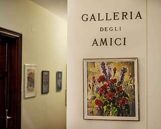 Entrée de la Galerie des Amis avec un tableau de fleurs accroché au mur