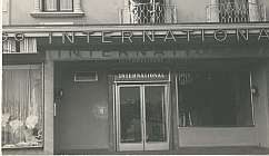 Entrée principale de l'hôtel International avec trois personnes sur le balcon au-dessus