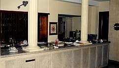 Comptoir de réception avec colonnes, téléphone et divers objets sur une surface en marbre