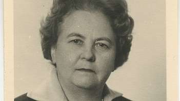 Primo piano di donna anziana con collana di perle e giacca scura