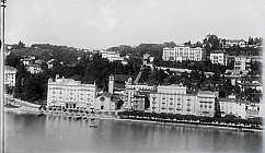 Panorama en noir et blanc d'un lac avec des bâtiments historiques et des collines en arrière-plan