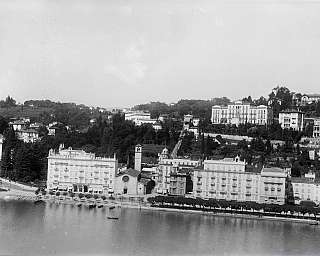 Panorama en noir et blanc d'une promenade au bord du lac avec des bâtiments historiques et des collines en arrière-plan