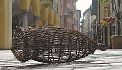 Panier en osier tressé posé sur un sol en pierre dans une rue de la ville