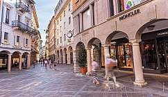 Fußgängerzone mit Luxusgeschäften und Menschen, die in einer europäischen Stadt spazieren gehen