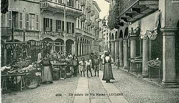 Rue historique avec des boutiques, des personnes et des enfants en vêtements d'époque à Lugano