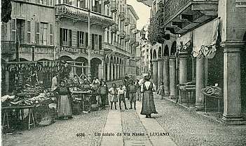 Historische Straße mit Geschäften, Menschen und Kindern in historischen Kleidern in Lugano