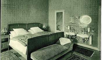 Chambre à coucher avec lit double, banc et deux lavabos avec miroirs