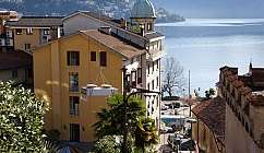 Vue de bâtiments aux toits rouges près d'un lac avec des montagnes en arrière-plan