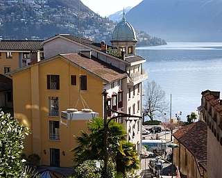 Bâtiments jaunes et blancs près d'un lac avec des montagnes en arrière-plan