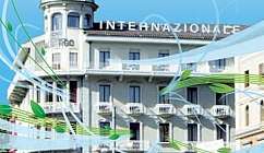 Façade d'un hôtel historique avec tourelle près du lac et végétation environnante