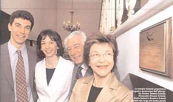 Quatre membres de la famille Schmid en tenue formelle dans un intérieur avec une plaque sur le mur