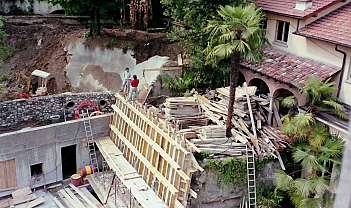 Chantier avec structure en bois, matériaux de construction et deux ouvriers debout