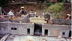 Chantier avec murs en béton, excavations, ouvriers et équipements de construction en cours d'utilisation