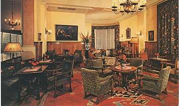 Intérieur d'un salon classique avec fauteuils, tables en bois, lampes et tableaux aux murs