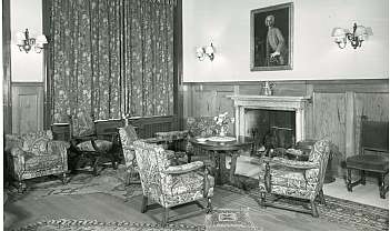 Salon vintage avec fauteuils, table ronde, cheminée en marbre et tableau sur le mur