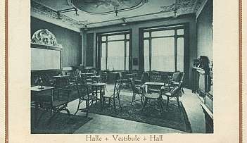 Intérieur d'une salle d'entrée avec des chaises, des tables et des décorations classiques