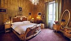 Chambre à coucher vintage avec lit sculpté, lustre et grand miroir ovale