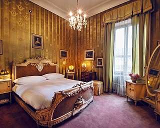 Chambre à coucher vintage avec lit sculpté, lustre et grand miroir ovale