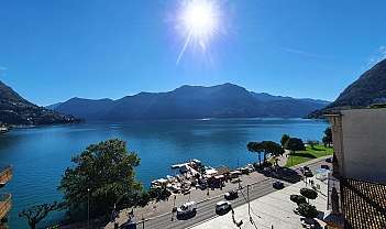 Vue panoramique d'un lac avec des montagnes en arrière-plan et une route avec des voitures au premier plan