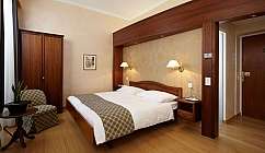 Chambre à coucher avec lit double, armoire en bois et fauteuil rembourré