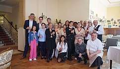 Groupe de personnes en tenue formelle et uniformes dans une pièce avec un sol en bois