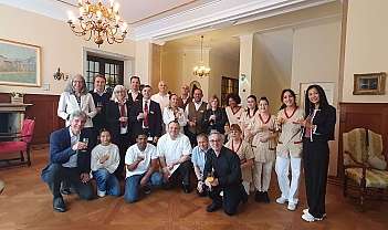 Groupe de personnes en tenue formelle et uniformes dans une pièce avec des verres à la main