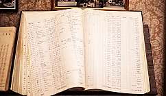 Livre de comptes ouvert avec des écritures et des chiffres manuscrits sur une table