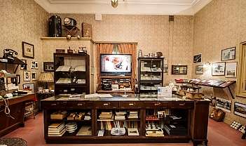 Salle avec meubles anciens, livres, téléphones et objets d'époque exposés
