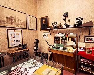 Intérieur d'une pièce avec des téléphones anciens, une machine à coudre et des tableaux aux murs