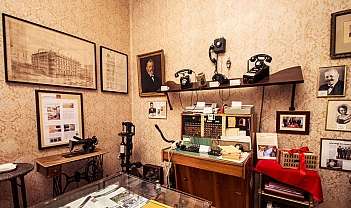 Intérieur d'une pièce avec des téléphones anciens, une machine à coudre et des tableaux aux murs