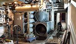 Local technique avec tuyauteries, machines industrielles et outils de maintenance