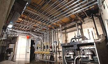 Intérieur d'une salle technique avec des tuyauteries métalliques et des équipements de contrôle