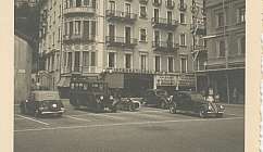 Bâtiment historique d'un hôtel avec des voitures anciennes garées devant sur une place