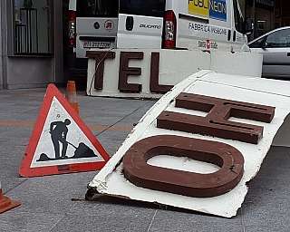 Panneau de signalisation de travaux en cours avec des cônes orange et des lettres d'enseigne sur le trottoir