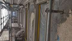 Ouvrier travaillant sur la façade d'un bâtiment en restauration avec des échafaudages