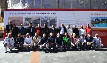 Groupe de personnes posant devant un grand panneau d'information en plein air