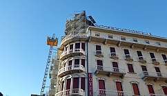 Façade d'un hôtel avec échafaudage et plateforme élévatrice en cours d'utilisation