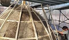 Personne travaillant à la construction d'une coupole avec une structure en bois et isolation