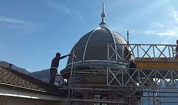 Deux ouvriers sur un échafaudage travaillent à l'entretien d'une coupole métallique