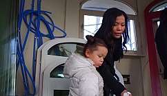 Femme et fille regardant quelque chose ensemble dans un environnement intérieur avec des fenêtres et des tuyaux bleus