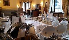 Matériaux de rénovation et sanitaires accumulés dans une pièce avec meubles et rideaux