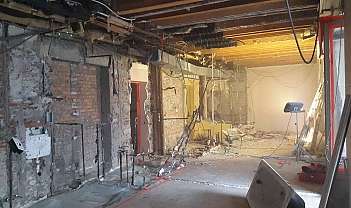 Intérieur d'un bâtiment avec des murs écaillés et des installations apparentes en cours de rénovation