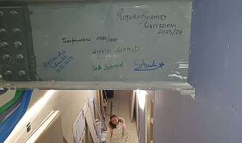 Poutre métallique avec signatures et inscriptions, fille en veste blanche en dessous