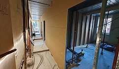 Intérieur d'un bâtiment en cours de rénovation avec des cloisons en plaques de plâtre et des tuyaux apparents