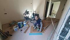 Ouvrier posant du parquet dans une pièce pendant des travaux de rénovation