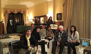 Huit personnes assises dans un salon élégant avec divers objets comme un lavabo et des miroirs