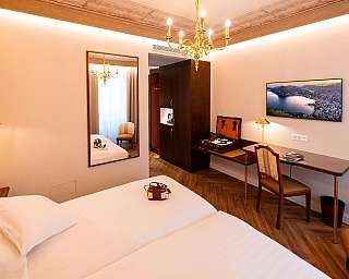 Intérieur d'une chambre d'hôtel avec lit, bureau et miroir.