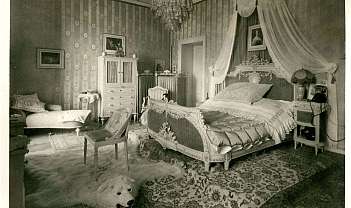 Camera da letto vintage con letto decorato, poltrona, tappeto e pelliccia di orso