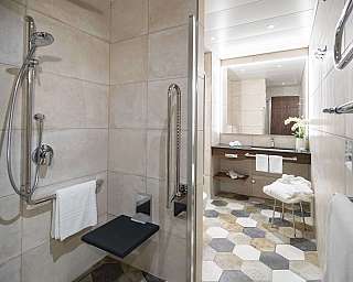 Intérieur d'une salle de bain avec douche, banc et sol hexagonal.
